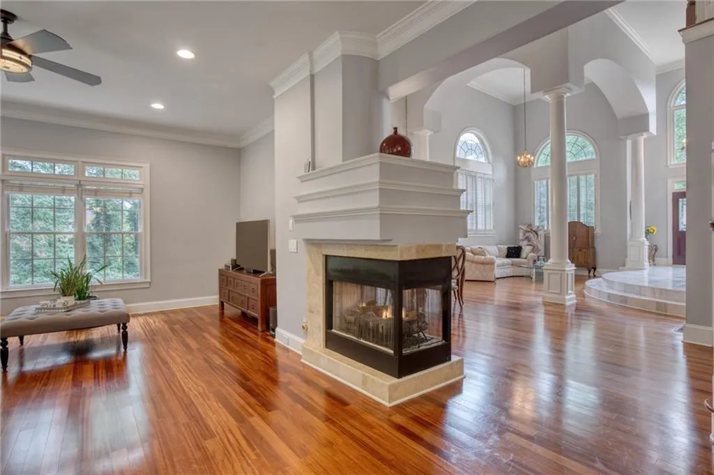 Living room featuring hardwood / wood-style flooring, a tile fireplace, ceiling fan, and plenty of natural light