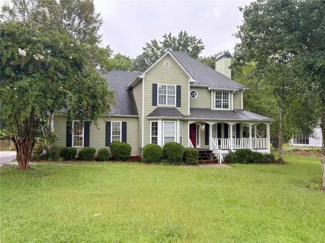 Two-story residence featuring light green siding and dark shutters