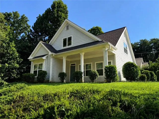 Light-colored horizontal siding exterior with a dark roof and white trim