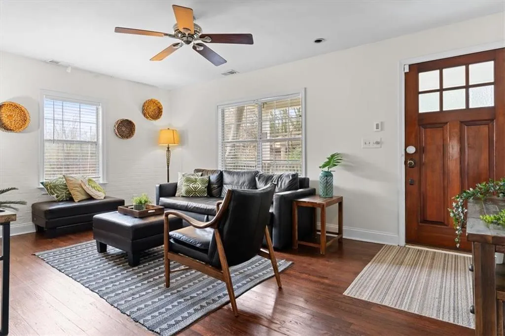 Living area featuring dark wood-style floors and ceiling fan