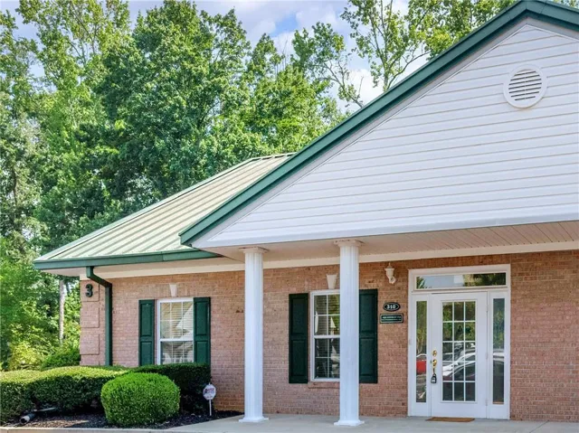 Brick exterior featuring a green metal roof and white siding
