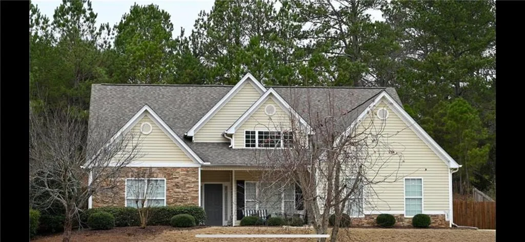 Exterior featuring stone facade, light-colored siding, multiple gables, and a prominent front porch