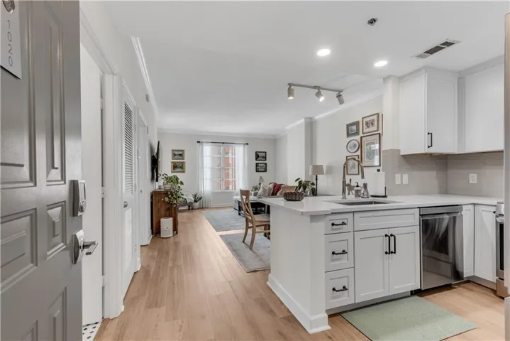 Open-concept living space with luxury vinyl tile flooring, recessed lighting, and crown molding