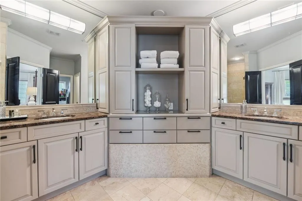 Primary bathroom features dual vanities, marble countertops and pleanty of cabinet space.