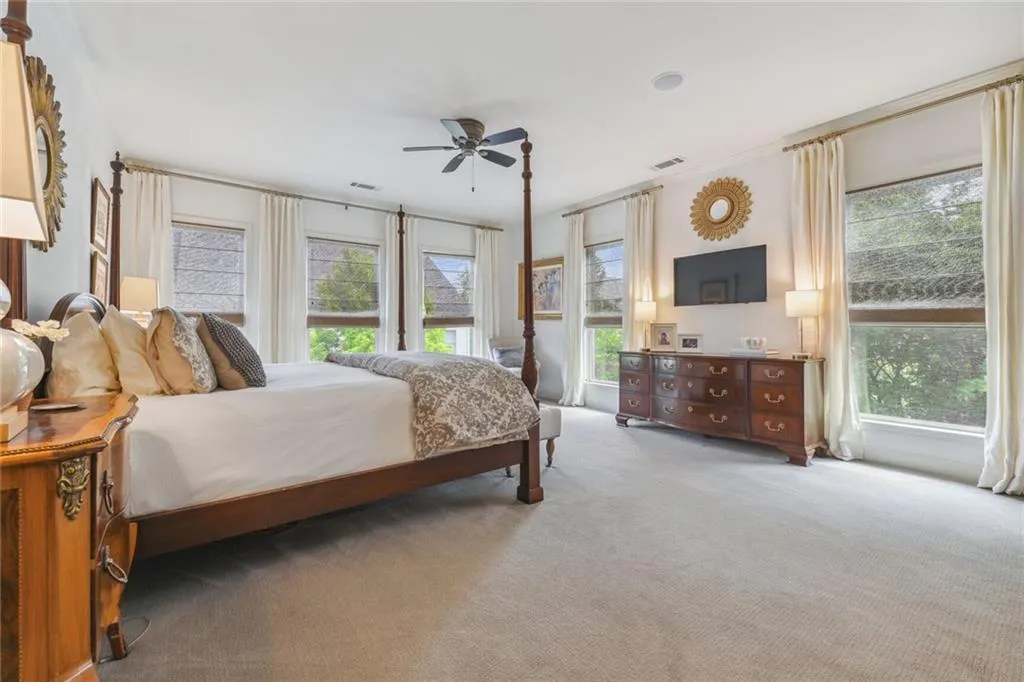 Spacious primary bedroom features a plethera of windows and a wealth of natural light.