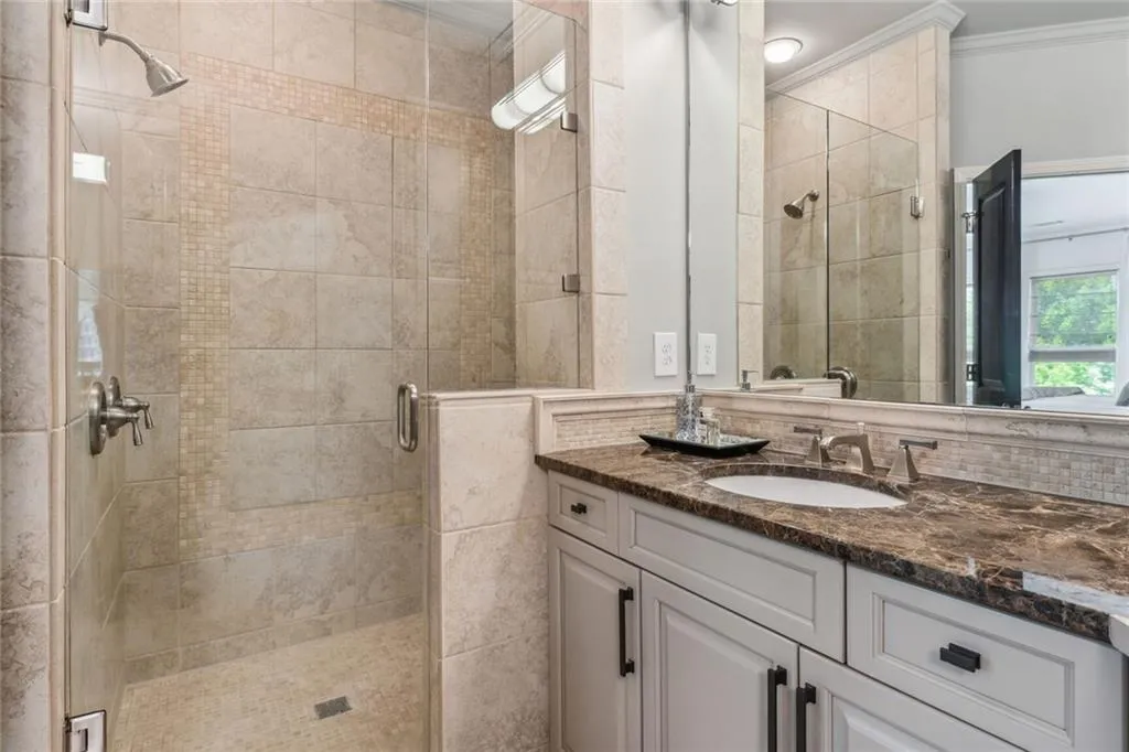 Primary shower includes frameless shower door and two shower facuets.