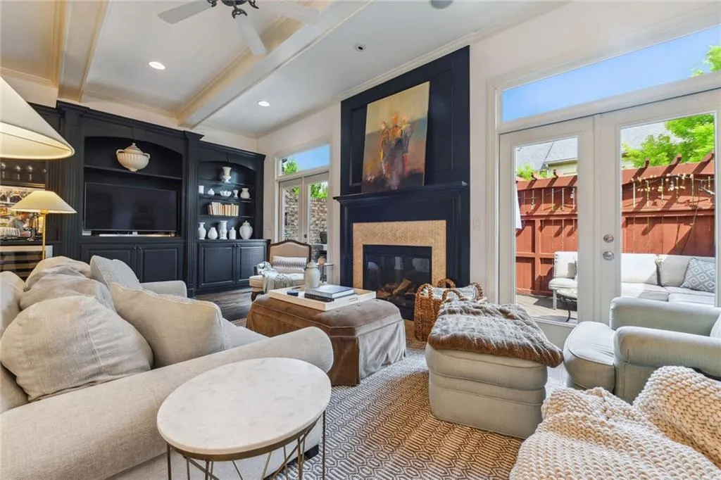 Living room with french doors leading to private deck, and gas fireplace, and built in cabinetry