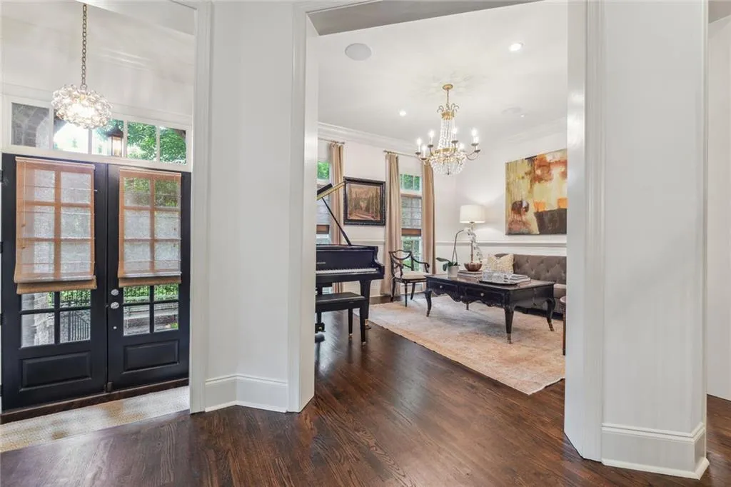 Foyer features french doors and a stunning chandelier.