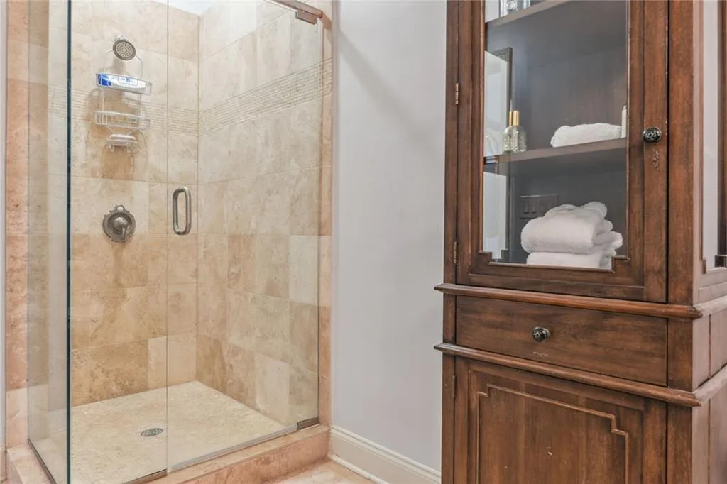 Terrace level ensuite bathroom has stone shower and frameless shower door.
