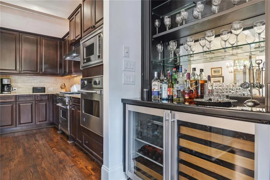 Wet bar includes wine refrigerator and beverage refrigerator.