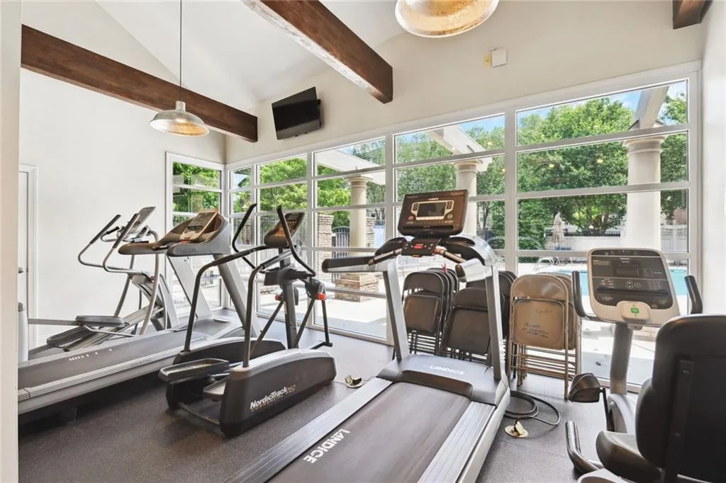 Fitness room in community clubhouse overlooks pool area.