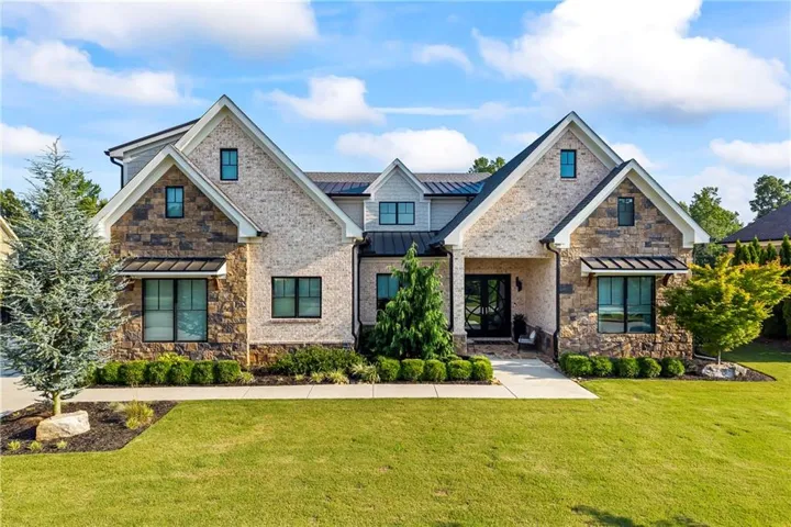 Gabled rooflines and a multi-textured facade featuring light-toned brick and stone accents