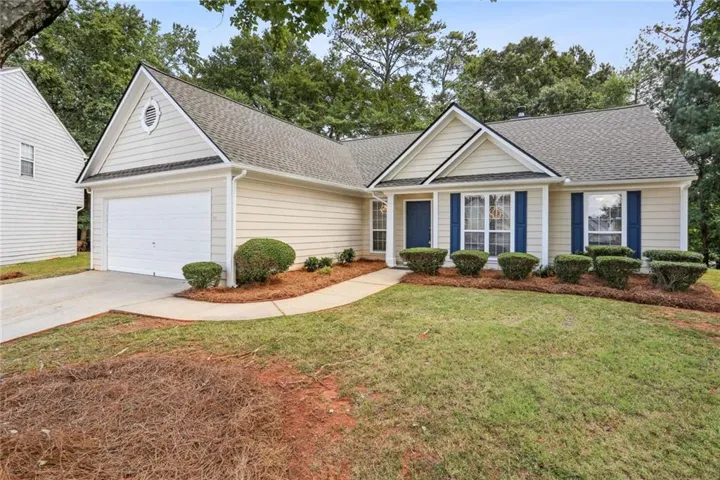View of front of home with a front yard and a garage