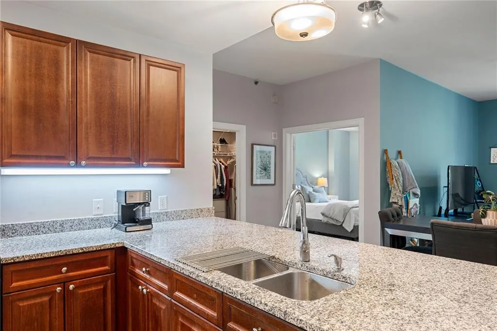 Kitchen featuring light stone countertops, open floor plan, and brown cabinets