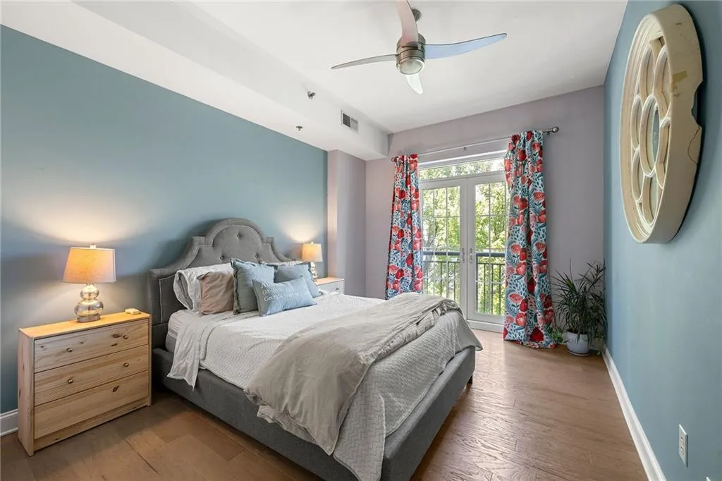 Bedroom with wood finished floors, a ceiling fan, and french doors