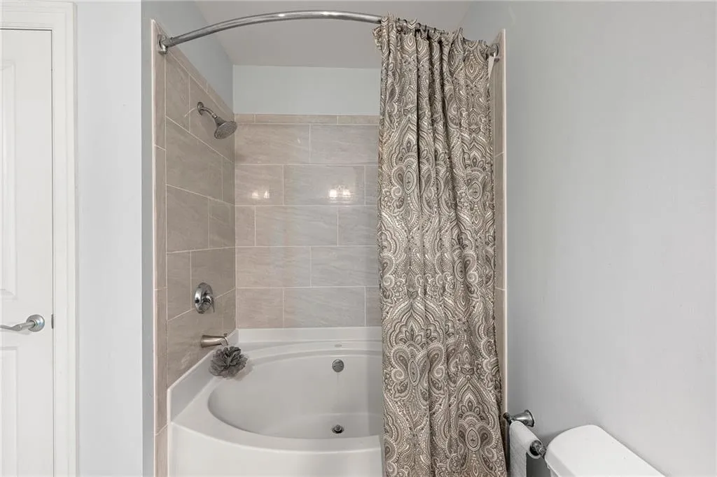 Bathroom featuring shower / bath combo and toilet
