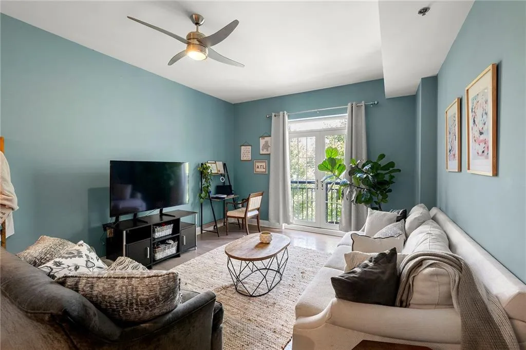 Living room featuring wood finished floors, ceiling fan, and french doors