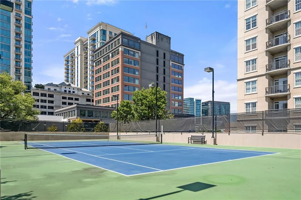 View of tennis court with community basketball court and a view of city