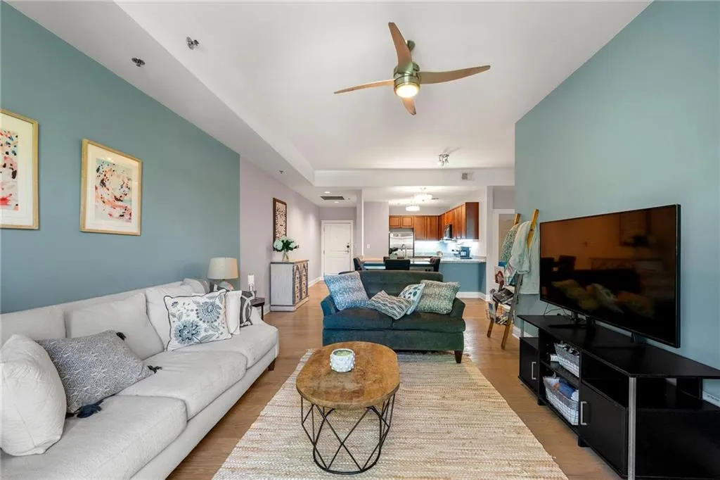 Living area with ceiling fan and light wood finished floors