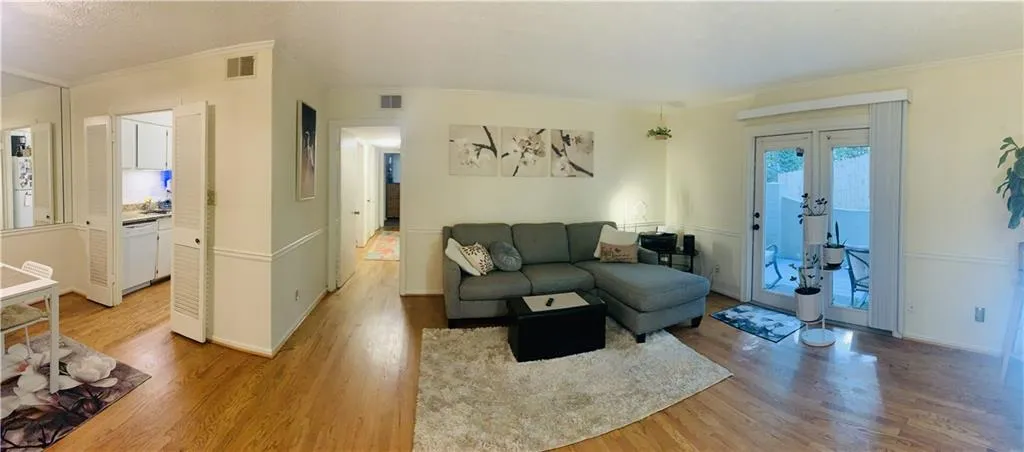 Living area featuring french doors, light wood finished floors, and ornamental molding