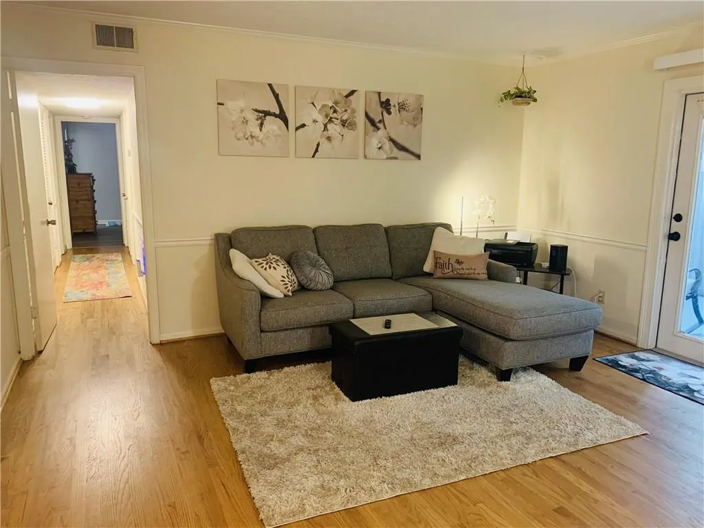 Living area featuring crown molding and light wood-style floors