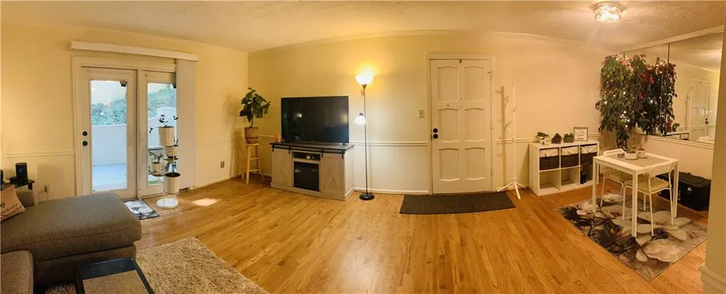 Living area with light wood finished floors and crown molding