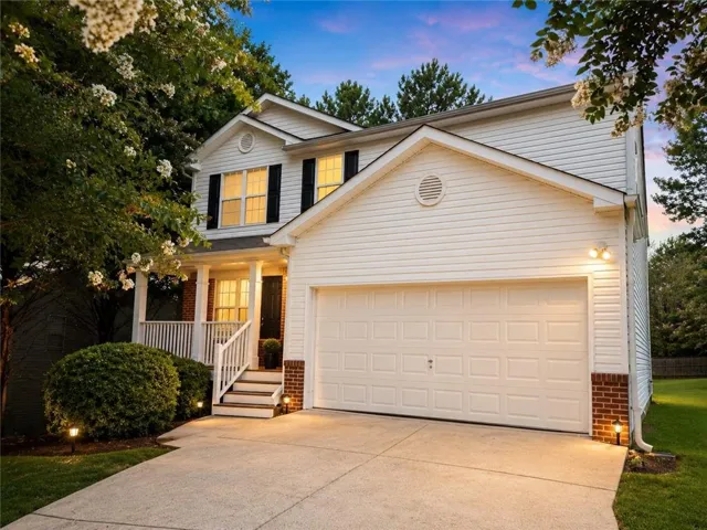 Two-story exterior with white siding and brick accents