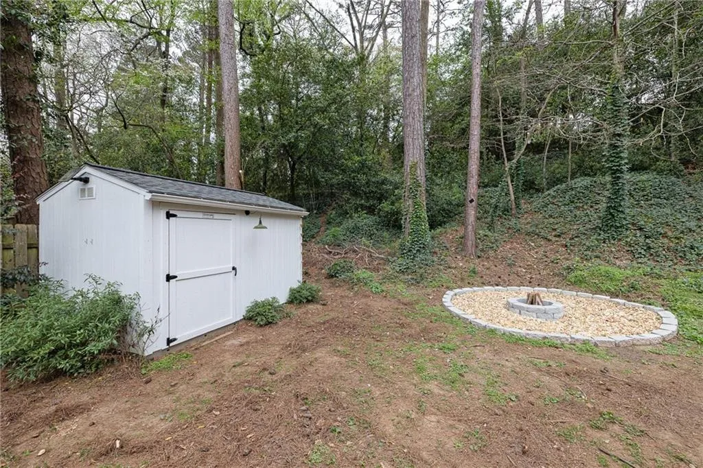 View of yard with an outdoor fire pit and a storage unit