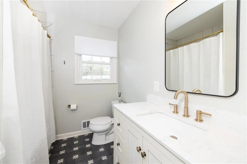 Bathroom featuring vanity, a shower with shower curtain, and dark flooring