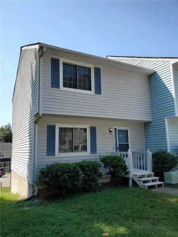 Two-story exterior with light-colored siding, contrasting blue shutters, and a front entry with steps