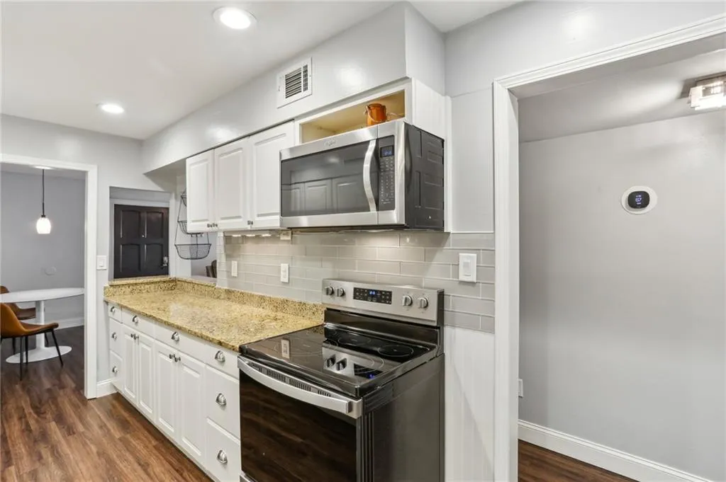 New five burner range with convection oven compliments the stainless appliances.