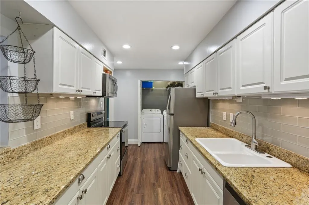 Laundry closet in kitchen comes with full sized washer and dryer