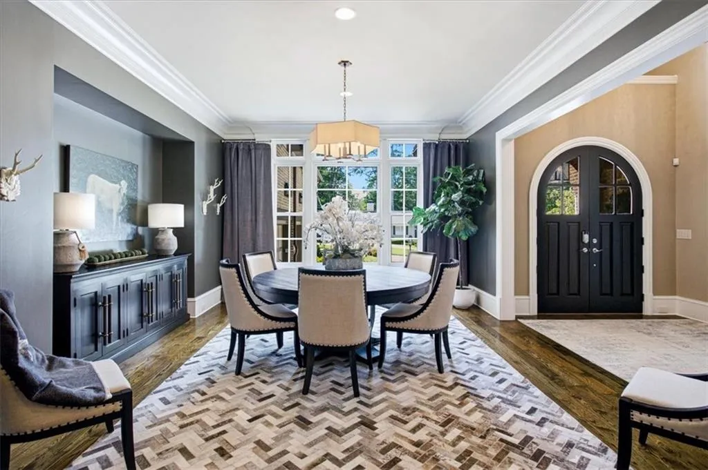 Formal dining area featuring hardwood flooring, extensive crown molding, a built-in credenza, and large windows