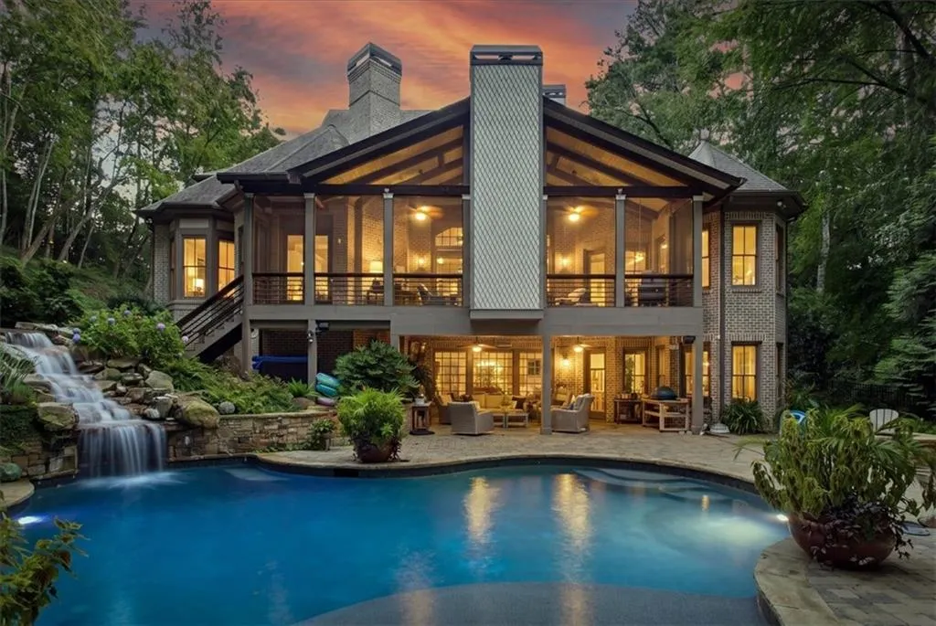 Expansive patio featuring a built-in pool with a rock waterfall