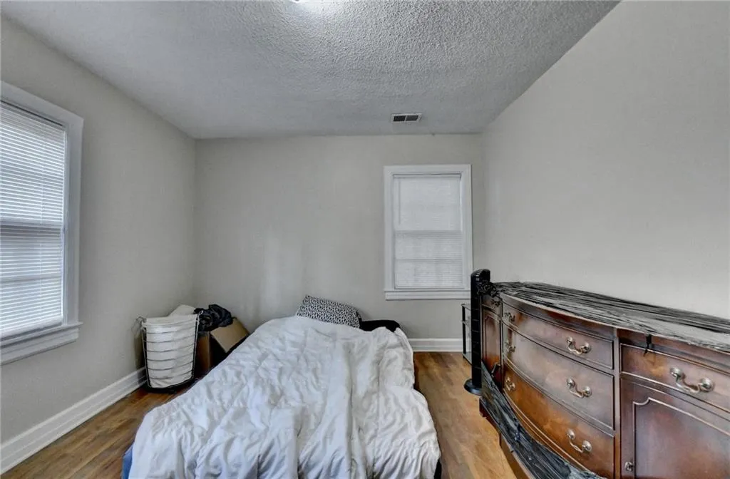 Bedroom featuring a textured ceiling and wood finished floors