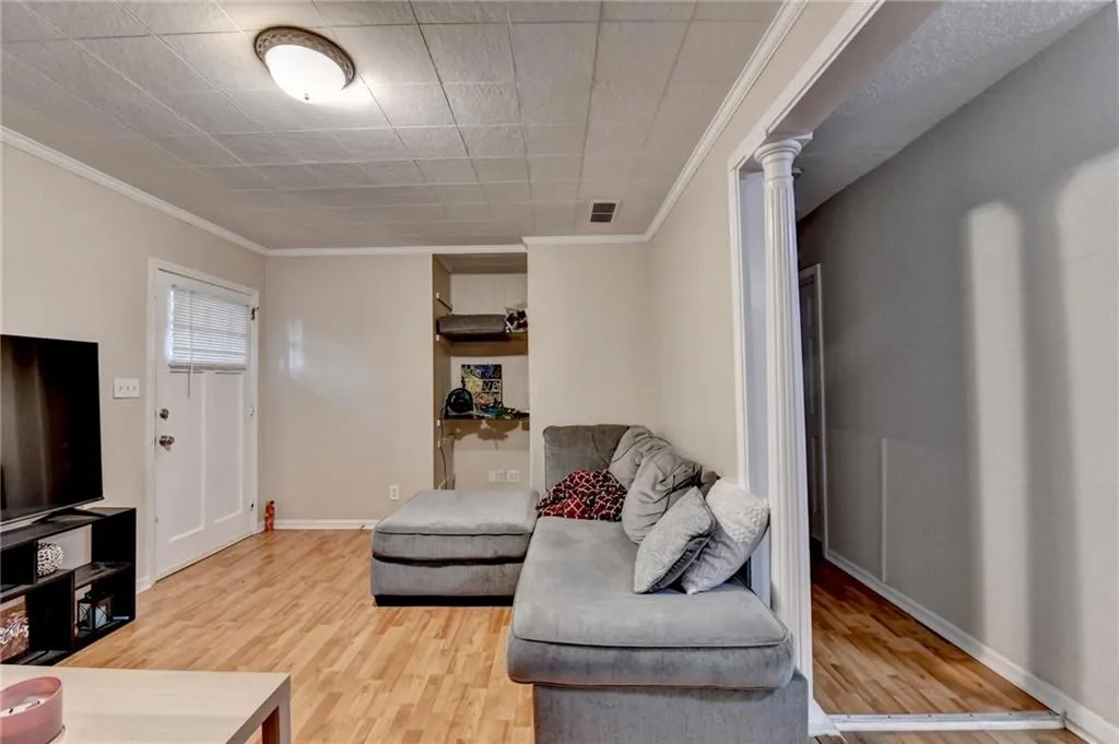 Living area with crown molding and light wood finished floors