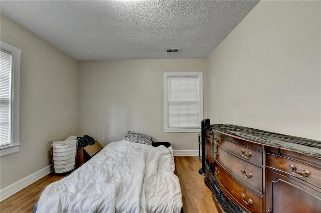 Bedroom with light wood-style flooring and a textured ceiling