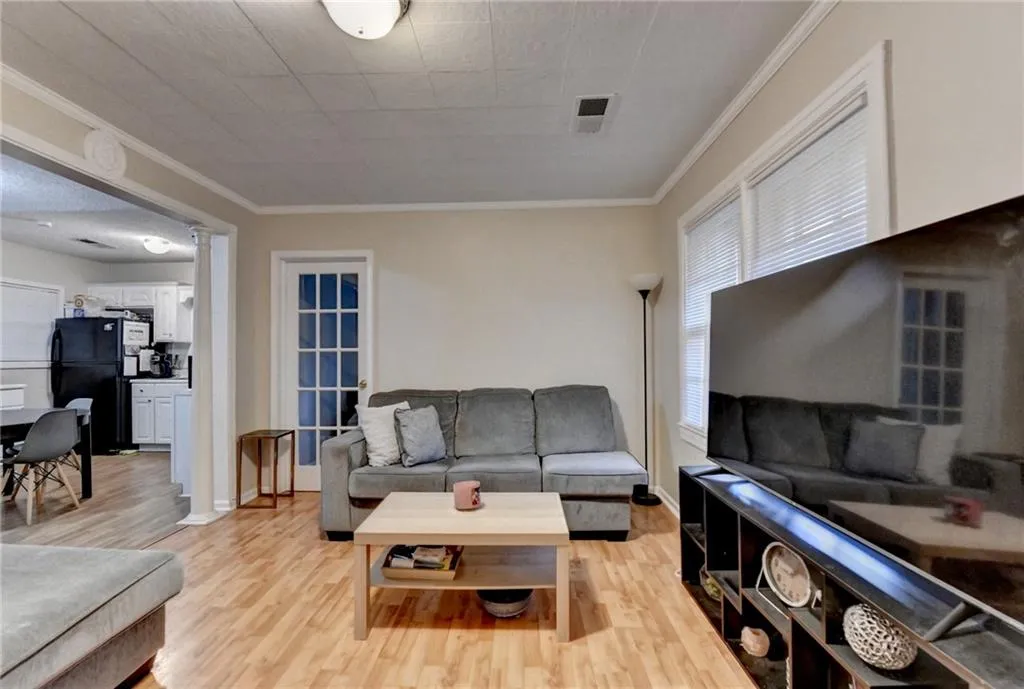 Living room featuring ornamental molding and light wood-type flooring