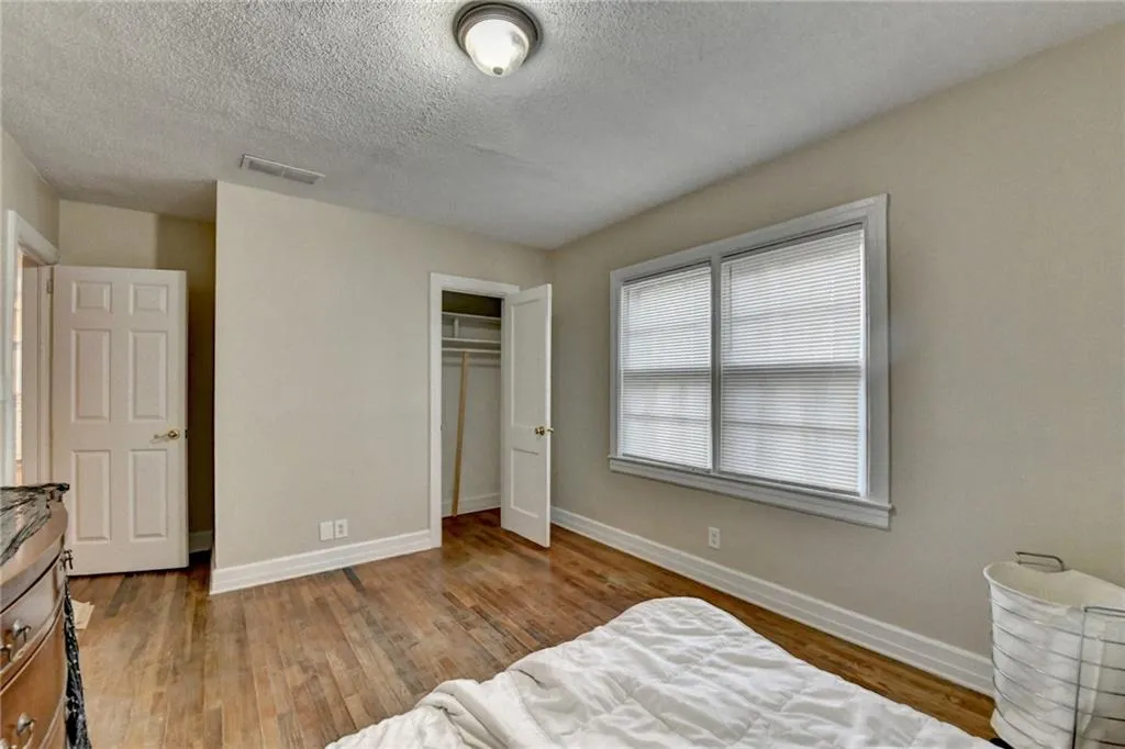 Bedroom featuring light wood-type flooring, a textured ceiling, and a closet