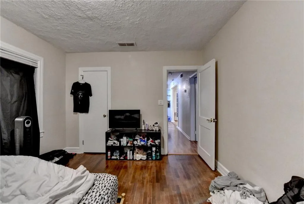 Bedroom featuring dark wood-type flooring, a textured ceiling, and a closet