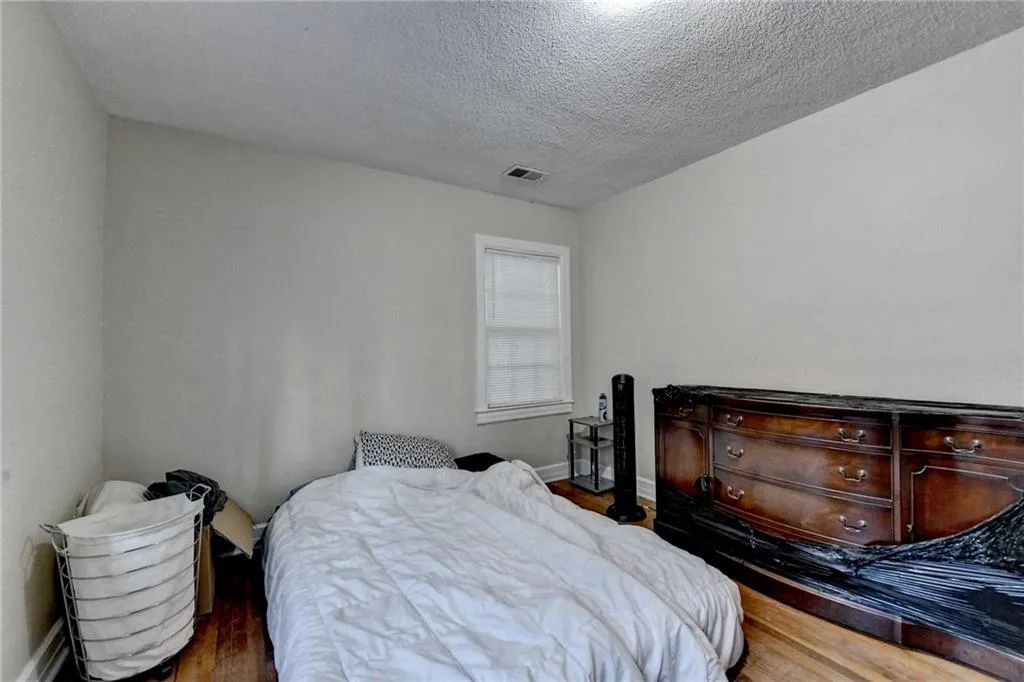 Bedroom featuring wood finished floors and a textured ceiling