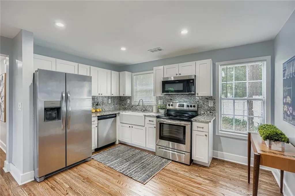 The kitchen has been renovated with white cabinets, stainless steel appliances and granite counters.  Notice the farmhouse sink!