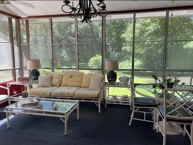 Sunroom / solarium featuring an outdoor living space, a chandelier, and a ceiling fan