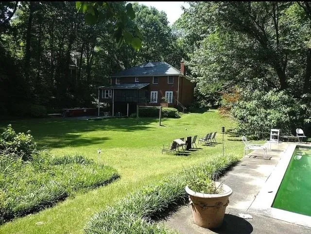 View of grassy yard featuring an outdoor pool and a patio