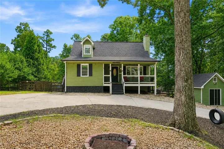 Traditional-style home featuring a covered front porch, dormer window, and an attached chimney