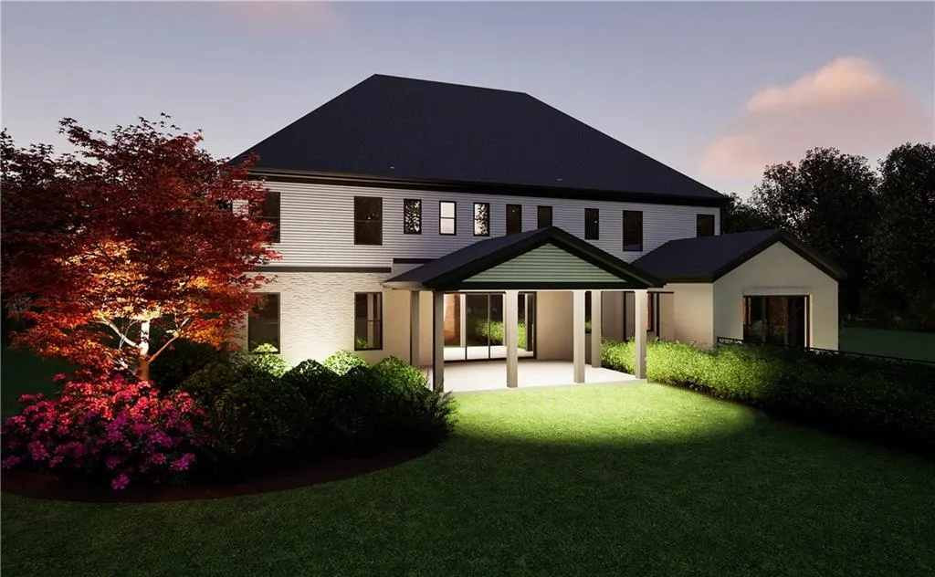 Back house at dusk featuring a yard and a patio area