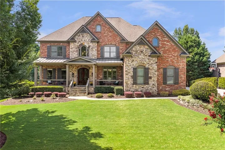 Brick and stone exterior with architectural shingles and arched windows