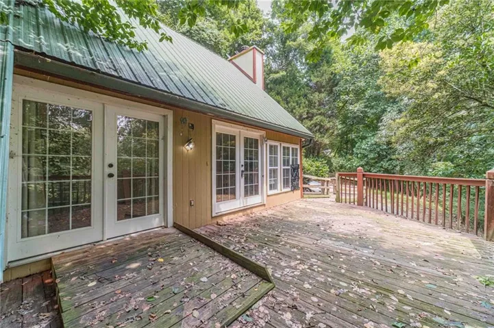 Expansive wood deck with a full railing system, surrounded by mature trees