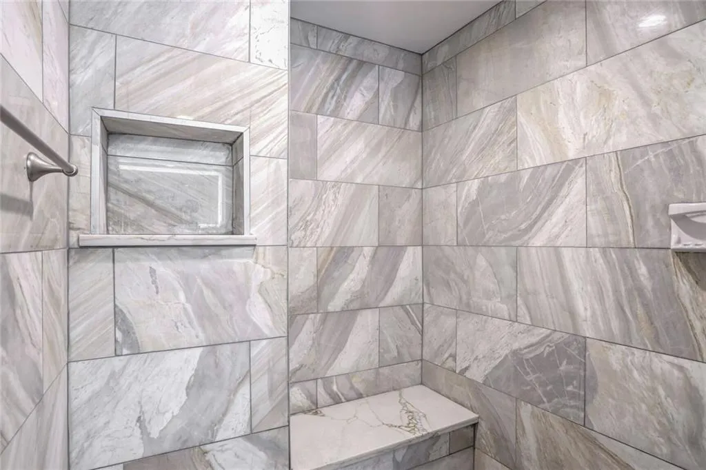 Huge Walk-in Shower with floor to ceiling Marble and a Bench.