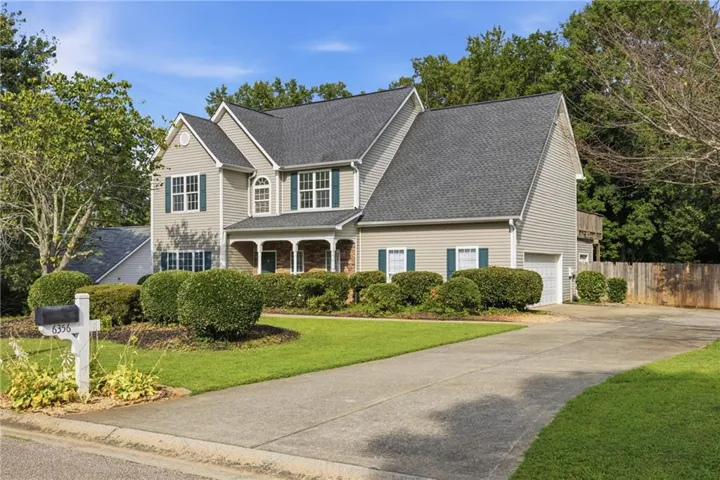 Two-story residence featuring siding exterior, a gabled roofline, and a prominent front porch with white columns
